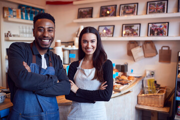 Portrait Of Smiling Couple Running Coffee Shop Together Standing Behind Counter