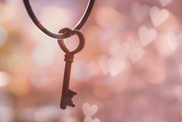 Old rusty vintage key in the shape of a heart, bokeh background with copy space. Love and...