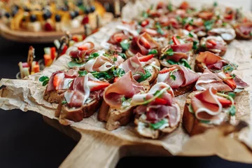 Fotobehang Festive Buffet. An assortment of cold cuts and canapes on wooden skewers. Cocktail reception at the party. catering with meats, fruits, cheeses and sandwiches. © AndreyZayats