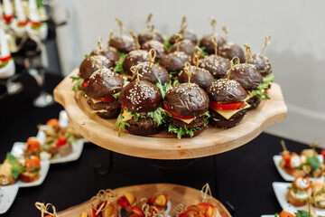 Festive Buffet. An assortment of cold cuts and canapes on wooden skewers. Cocktail reception at the party. catering with meats, fruits, cheeses and sandwiches.