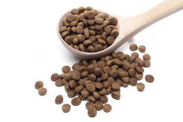 Dog food, dry round granules for pets in wooden spoon isolated on white background