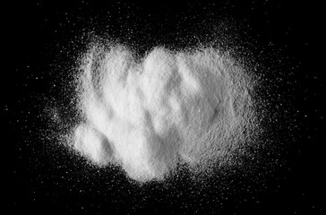 Baking soda pile, sodium bicarbonate isolated on black background, top view