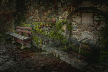 bench in a mountain village near running water