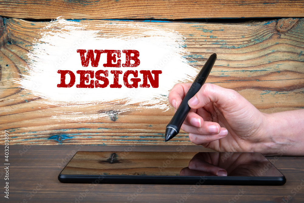 Poster web design concept. tablet on a wooden table. woman's hand writes and draws on a computer