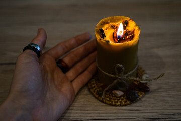 A hand holds a wax candle. Spiritual ceremony