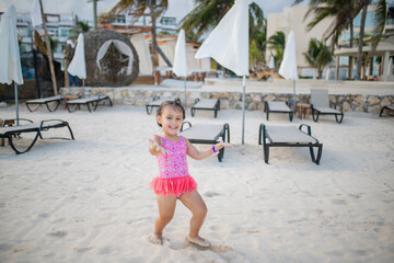 Happy and adorable little girl on the beach