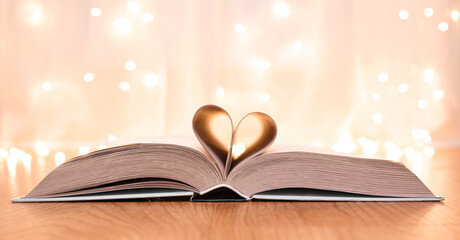 Heart-shaped pages of book on bokeh background. St. Valentine's concept.Valentine's card.