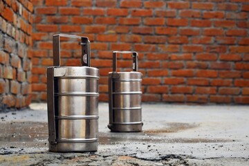 Indian stainless steel tiffin boxes or lunch boxes on construction site with copy space