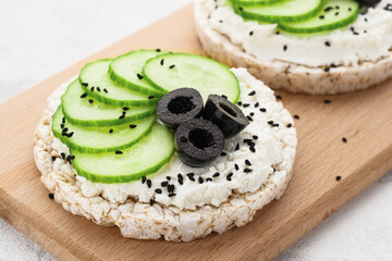 Close up rice cakes with cream cheese and cucumber with olives