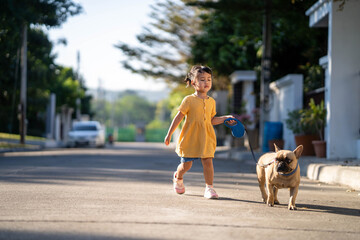 Cute little girl out walking her dog at village.