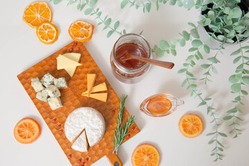 カッティングボードに乗せた色々なチーズと蜂蜜