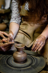 Pottery classes, student making clay pot on wheel. Close-up of dirty hands, sculpting clay crockery pottery training