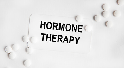 Obraz premium On the card text hormone THERAPY, next to the white tablets.