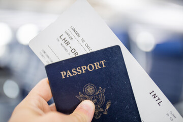 Male hand holding American passport and airplane ticket
