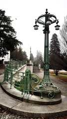 vintage street lamp

an old lamp on the path next to the building and the trees
