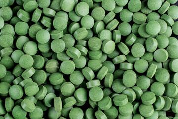 chlorela freshwater algae in a pill on a black background..