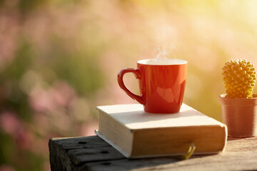red cup of coffee with flower garden background