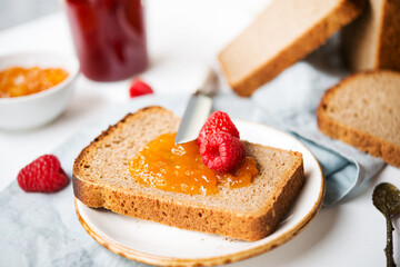 Fresh homemade bread with jam and milk, homemade simple food, light background