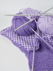 Needlework crochet, top view of yarn balls, flat spoon on light wood close-up