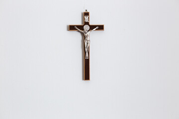 Crucifix of Jesus Christ on white wall in catholic family home. Christian background with copy...