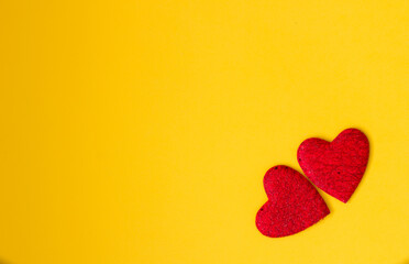 Two red hearts on a yellow background. Festive background. Minimalism. Copy space