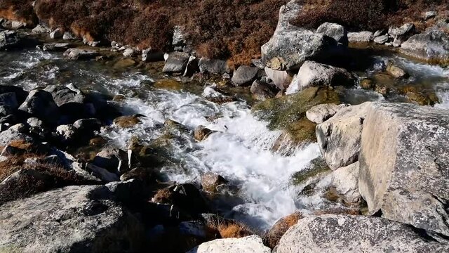 Flowing water in small mountain stream with rocks in Gokyo valley, Nepal in the Himalayas.