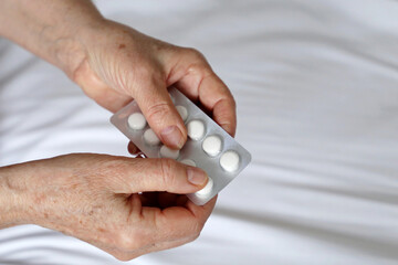 Elderly woman with pills in wrinkled hands. Concept of medication for heart, sedatives	