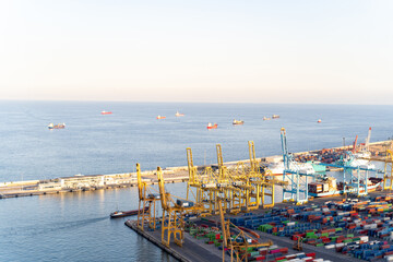 Naklejka na ściany i meble Aerial view to a sea cargo port with containers, cranes and ships in Barcelona