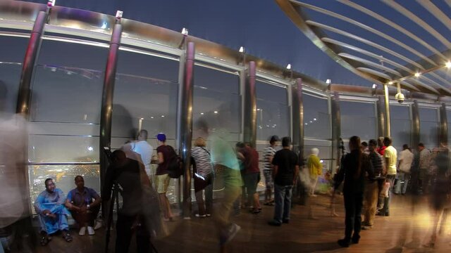 At The Top - Observation Deck of Burj Khalifa at night with crowd. Dubai, United Arab Emirates timelapse. Crowd of people making pictures on viewpoint