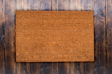 Natural coir doormat on antique wooden texture, background