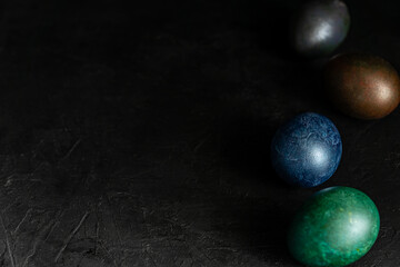 colorfull marble painted easter eggs on black background. Concept of minimal festive Easter backdrop