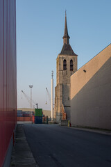Containers and Church of Wilmarsdonk in the Port of Antwerp. Wimarsdonk was a village that was sacrificed to the expansion of the port and was destroyed in 1965. Only the church tower was preserved.