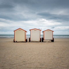 Three painted beach cabins on the beach of De Panne in Belgium
