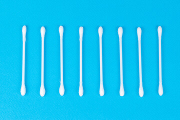 White cotton swabs on blue background.