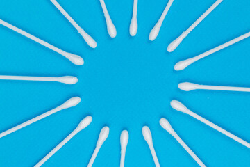 White cotton swabs on blue background.