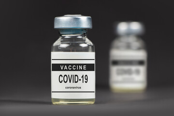 Covid-19 vaccine on a laboratory bench. to fight the coronavirus sars-cov-2 pandemic. Dark bacground