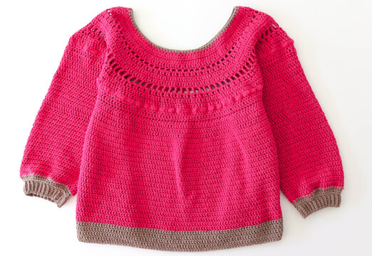 Pink and brown jumper knitting with crochet needle. Jersey rosa y marr&oacute;n tejido a mano a ganchillo con fondo blanco.