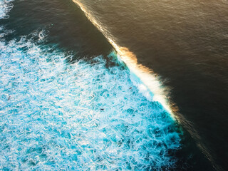 breaking wave during sunset shot from a drone