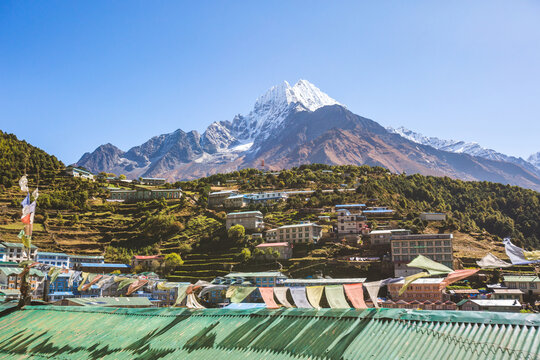 Prayer flags with Buddhist mantras in the background of Namche Bazar village. Nepal
