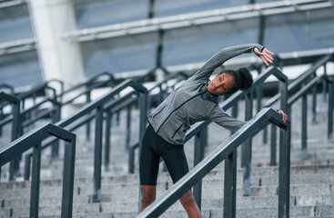 On the stairs. Young african american woman in sportive clothes have workout outdoors at daytime