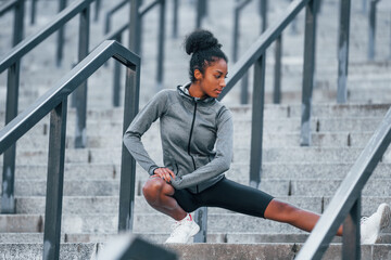 On the stairs. Young african american woman in sportive clothes have workout outdoors at daytime