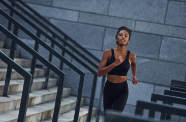 Active runner. Young african american woman in sportive clothes have workout outdoors at daytime