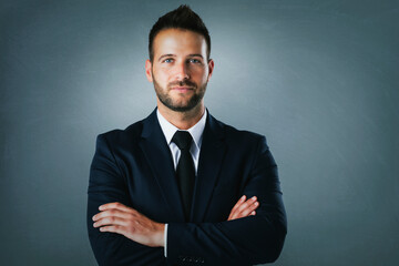 Close-up studio portrait of confident businessman wearing suit and tie and smiling while standing at isolated background. Copy space. 