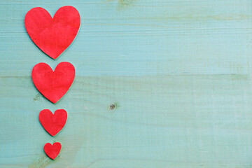 Background of four wooden hearts on an old rustic white table