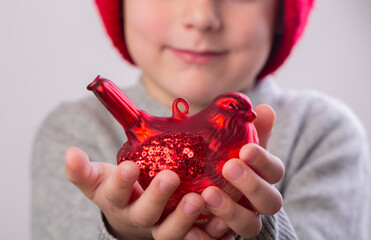 Little boy holding a red bullfinch christmas toy