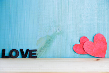 Two handmade hearts against rustic wooden background. Love concept.