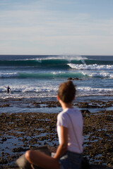 young woman watching surfers