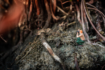 Miniature photographer taking photo of beautiful landscape
