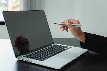 Hands of businesswoman in casual talking about the business plan and pointing at a computer screen to explain to colleagues.