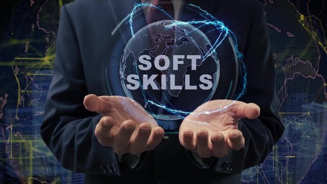 Male hands activate a conceptual holographic text Soft Skills. Businessman in a suit with a hologram of planet Earth on a background of a futuristic wireframe city